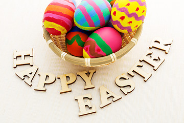 Image showing Painted easter egg in basket with wooden text 