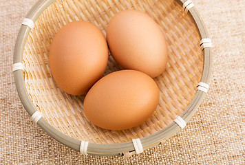 Image showing Brown egg in basket over linen background