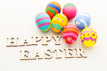 Image showing Children painted easter egg with wooden text