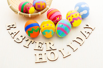 Image showing Pattern easter egg in basket with wooden text