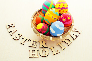 Image showing Easter egg in basket with wooden text