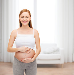 Image showing happy future mother touching her belly