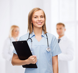 Image showing smiling female doctor or nurse with clipboard