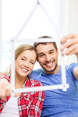 Image showing smiling couple with house from measuring tape