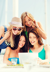 Image showing girls looking at tablet pc in cafe