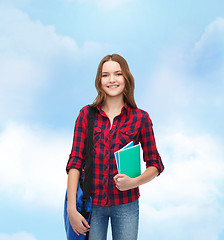 Image showing smiling female student with bag and notebooks