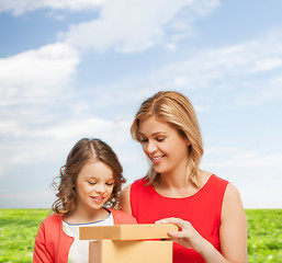 Image showing smiling mother and daughter with gift box