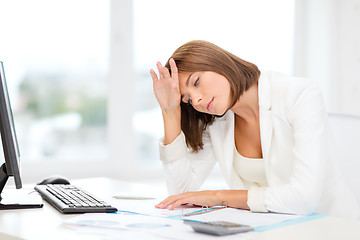 Image showing tired businesswoman with computer and papers