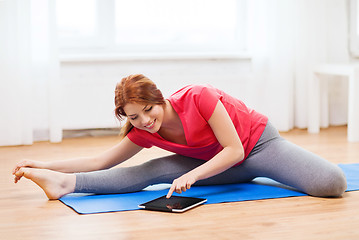 Image showing smiling teenage girl streching on floor at home