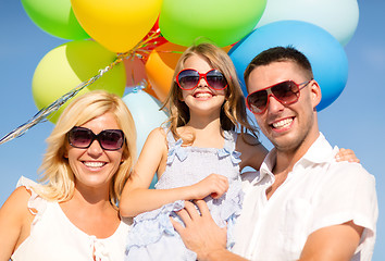 Image showing happy family with colorful balloons outdoors