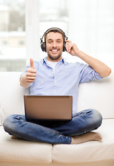 Image showing smiling man with laptop and headphones at home