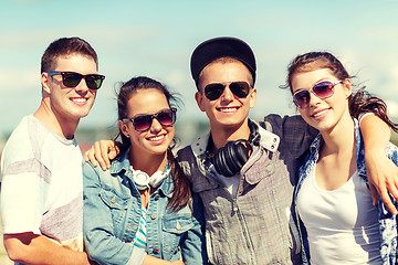 Image showing smiling teenagers in sunglasses hanging outside