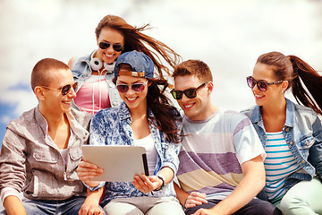 Image showing group of smiling teenagers looking at tablet pc