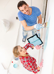 Image showing smiling couple painting wall at home