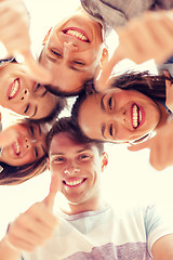 Image showing group of smiling teenagers looking down