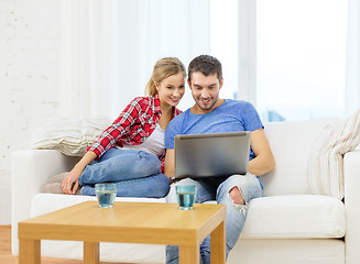 Image showing smiling couple with laptop computer at home