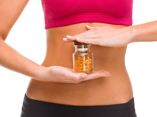 Image showing close up of female hands with bottle of capsules