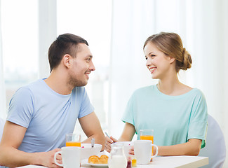 Image showing smiling couple having breakfast at home