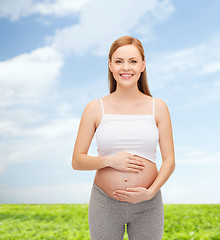 Image showing happy future mother touching her belly