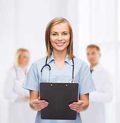 Image showing smiling female doctor or nurse with clipboard