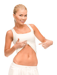 Image showing beautiful sporty woman pointing at her abs