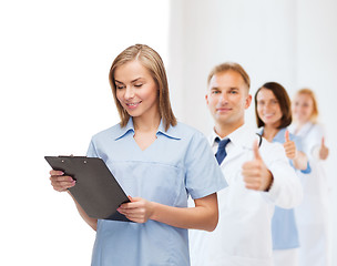 Image showing smiling female doctor or nurse with clipboard