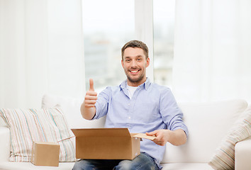 Image showing man with cardboard boxes at home showing thumbs up