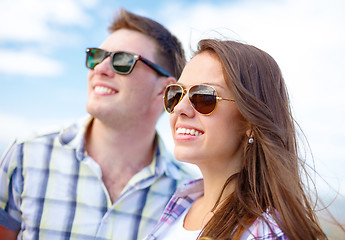 Image showing smiling teenagers in sunglasses having fun outside