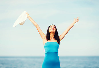 Image showing girl with hands up on the beach