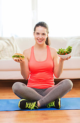 Image showing smiling teenager with green salad and hamburger