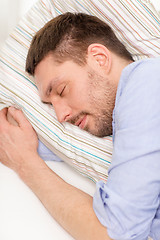 Image showing calm young man lying on sofa at home