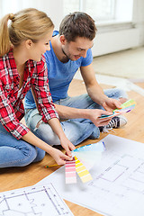 Image showing smiling couple looking at color samples at home