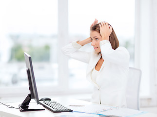 Image showing stressed businesswoman with computer at work