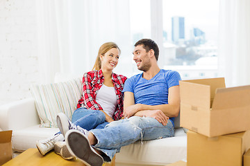 Image showing smiling couple relaxing on sofa in new home