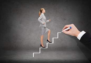Image showing smiling businesswoman stepping up staircase