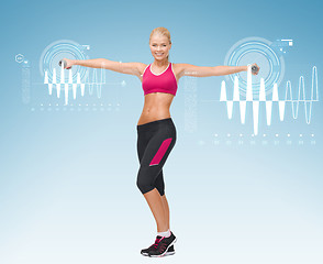 Image showing young sporty woman with light dumbbells