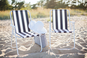 Image showing two beach lounges with beach bag and white hat