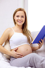 Image showing pregnant woman reading book at home