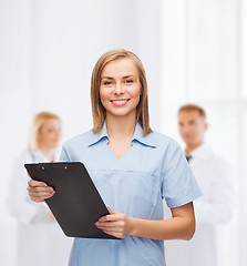 Image showing smiling female doctor or nurse with clipboard