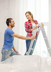 Image showing smiling couple hanging curtains