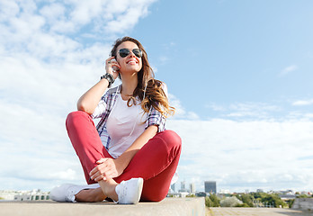 Image showing smiling teenage girl in eyeglasses with headphones