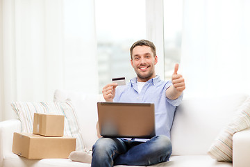 Image showing man with laptop, credit card and cardboard boxes