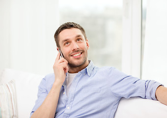 Image showing smiling man with smartphone at home