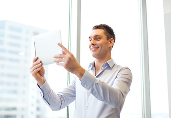 Image showing smiling businessman with tablet pc in office