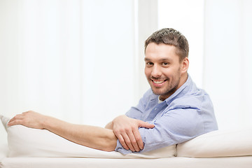 Image showing smiling man sitting on sofa at home