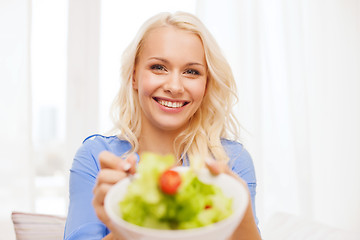 Image showing smiling young woman with green salad at home