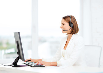 Image showing friendly female helpline operator with computer