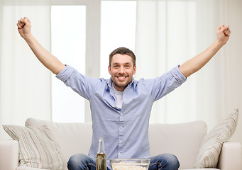 Image showing smiling man watching sports at home