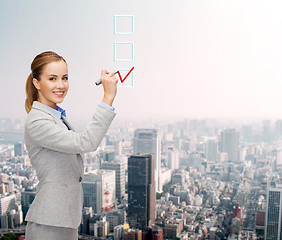 Image showing businesswoman writing something in air with marker