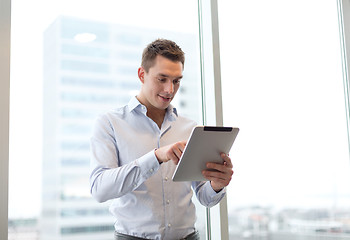 Image showing smiling businessman with tablet pc in office